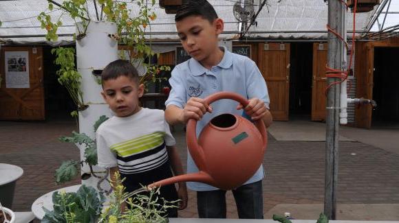 two boys watering plants